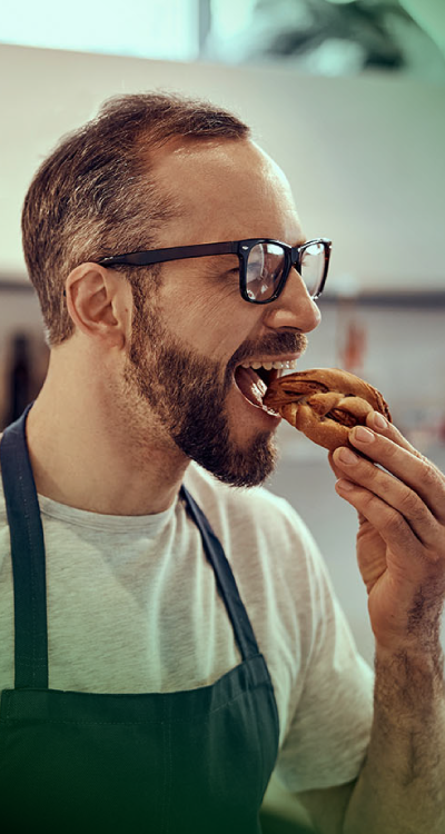 Man enjoying a bold-flavored cookie, reflecting the emotional appeal and sensory intensity of maximalist taste trends.