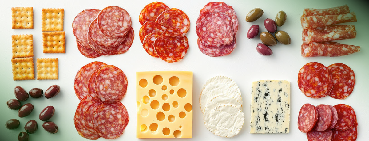 Vibrant charcuterie board with meats and cheeses, showcasing maximalism in taste through bold variety and contrast.