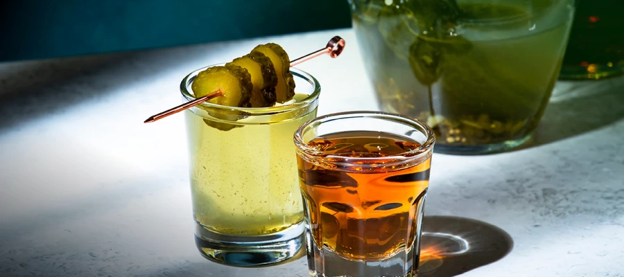 Cocktails garnished with pickle spears highlighting modern pickle trends