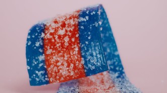 Candy square with sugar crystals, suggesting encapsulation/surface layering for fast aroma release