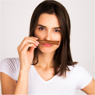 A woman smelling a flower, reflecting curiosity and discovery in the world of flavor and aroma.