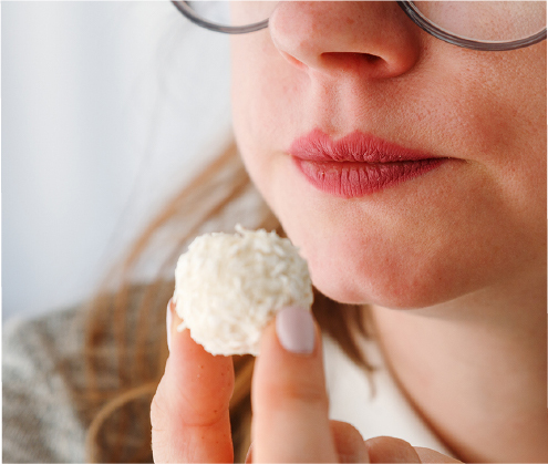 A woman biting into a soft, airy snack, showing how eating habits shape texture preferences.