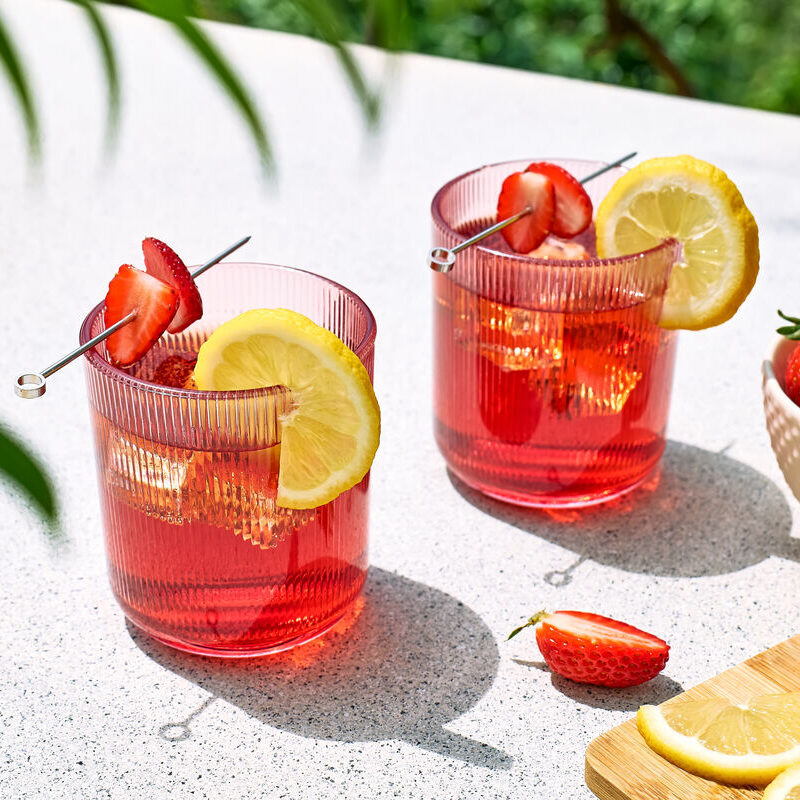 Still strawberry drink—intentional lift without bubbles to avoid jammy drift.