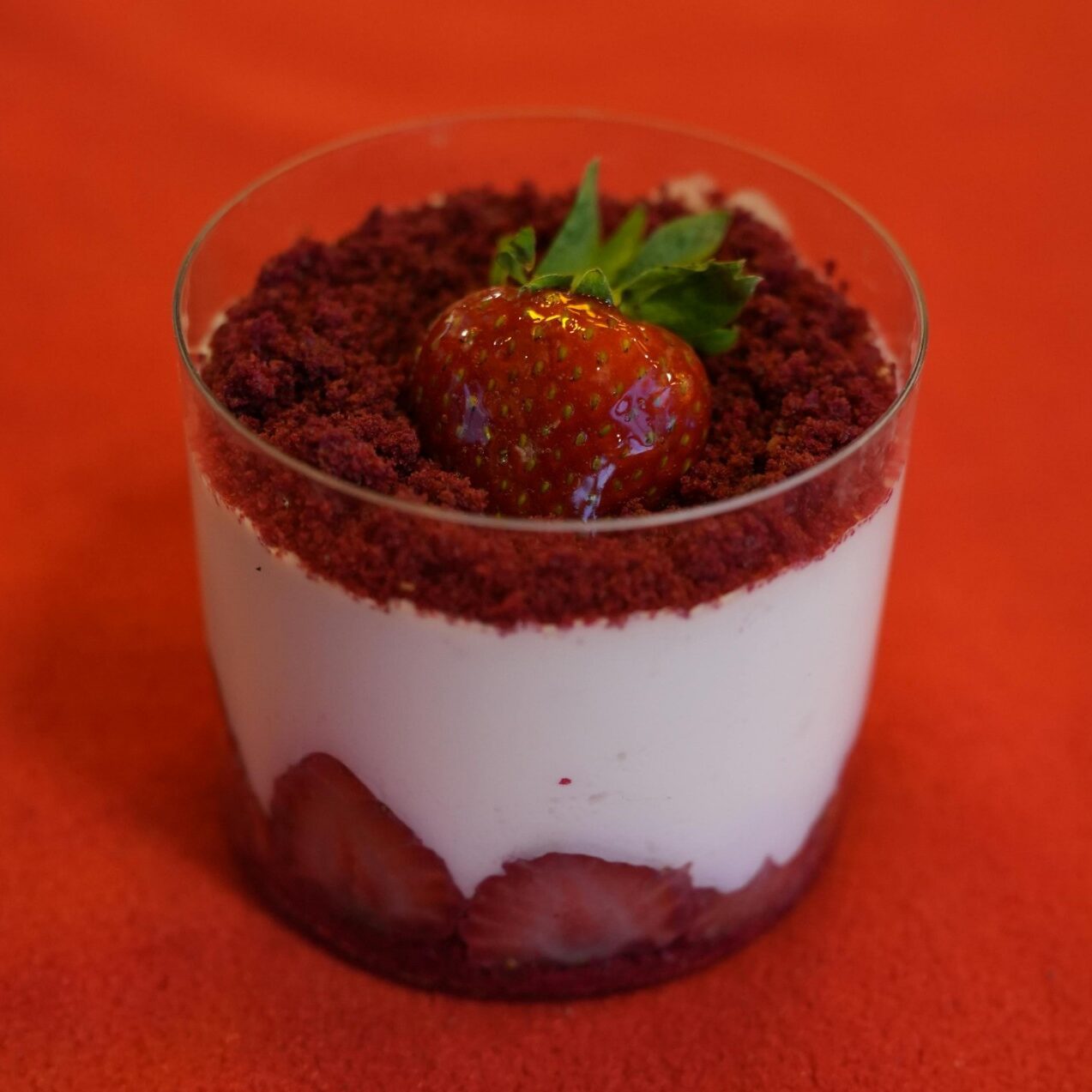 Red dessert cup with berries, showing color can support sweetness perception when the flavor system is aligned.