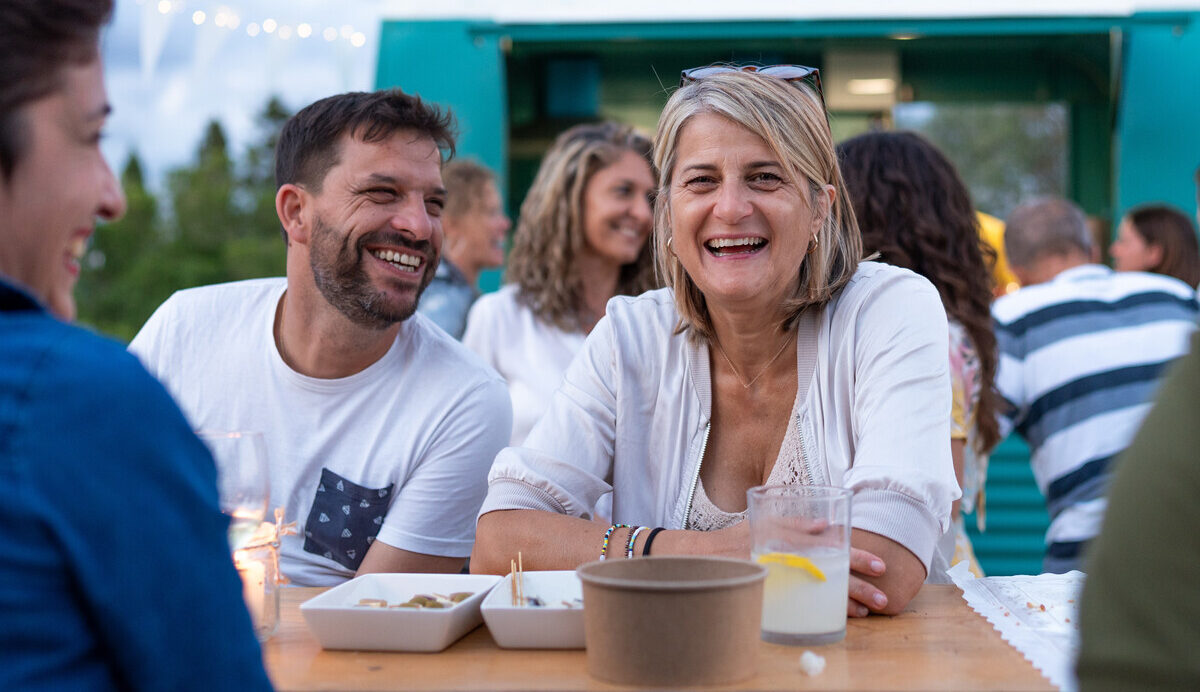 Friends enjoying drinks outdoors, showing mood-led occasions for herbal and floral flavors.