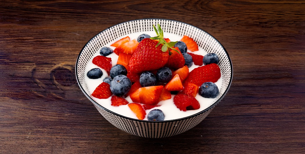 Coffee cup with blueberries and cherries, showing fruit notes that need structure in coffee flavor development.